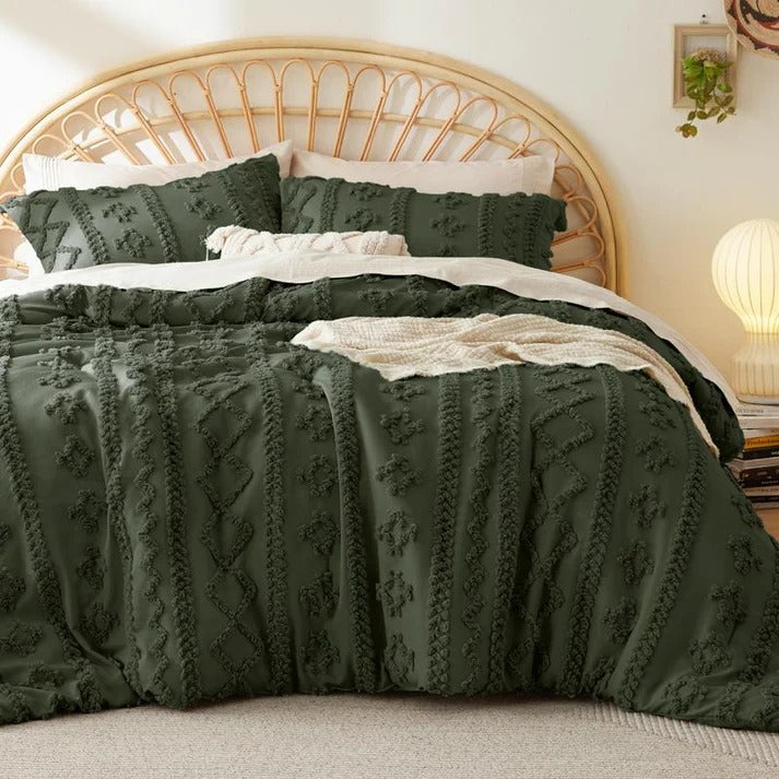 Olive green tufted bedding draped over the sides of a bed